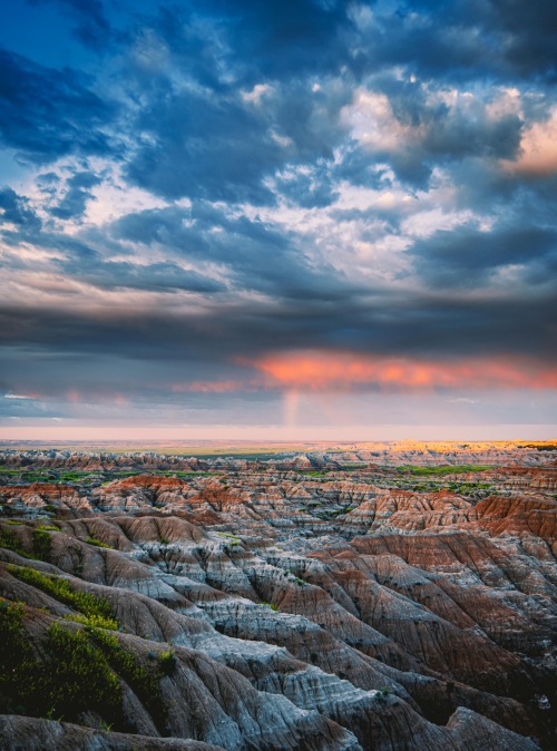 landscape of the badlands with layered canyons and a cloudy sky overhead